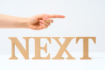 「NEXT」と並べられたアルファベットの木製ブロック