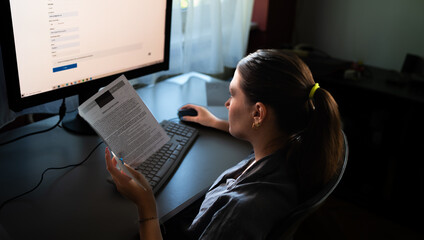 A young woman is sitting at a computer in the office