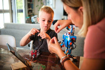 A tender moment reveals teamwork as a mom and her son engage in the step by step process of constructing a robotic figure, illustrating patience and co-operation at home.