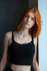 Fototapeta premium Cute red-haired girl, studio portrait on a black background.