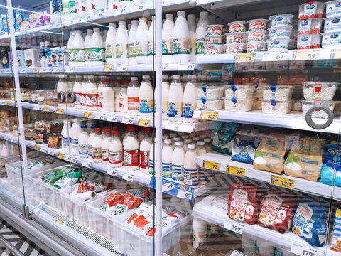 Supermarket background. Shelves with dairy products. Grocery. Retail industry. Rack. Discount. Aisle. Consumer packaged goods. CPG. Store. Bottles of milk. St. Petersburg, Russia - March 10, 2022: