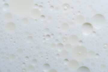 Oil drops on white background with copy space. Macro photography of water bubbles.