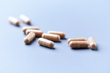 Carnitine capsules. Concept for a healthy dietary supplementation. Bright paper background. Soft focus. Close up.
