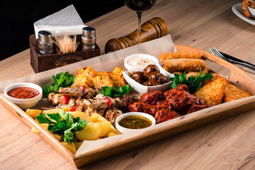 Beef barbecue on a skewer with mushrooms, fried chicken legs, rustic fried potato wedges, cheese...