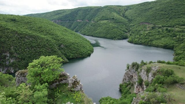 Aerial view of old fortress Bocac ruins covered in forest with the river Vrbas in the background