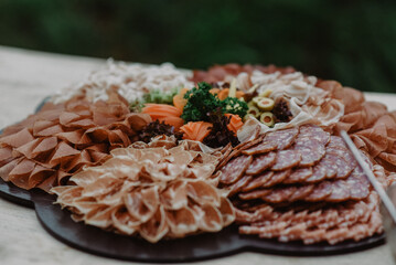 Charcuterie plate with arranged meats on a wooden table.