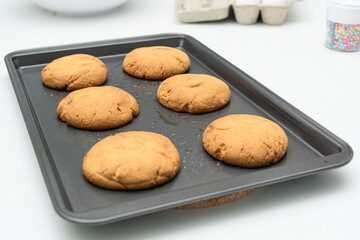Freshly baked cookies cooling on a tray in modern kitchen