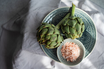 Raw green artichoke bud on the table