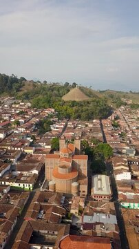 Aerial view of the town of Jeric&oacute;, Antioquia, showcasing its beautiful architecture and lush green surroundings, nestled among rolling hills.