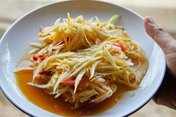 Spicy green papaya salad or Som Tum Thai food served on plate