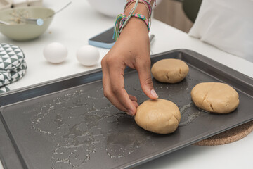 Close up view female hand preparing cookie dough.