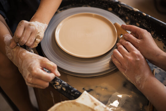 Pottery lesson master class, process of making clay plate on pot