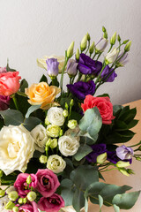 A beautiful bouquet of vibrant roses, eucalyptus, and delicate eustoma in white, pink, and purple hues, perfect for a summer anniversary or birthday celebration