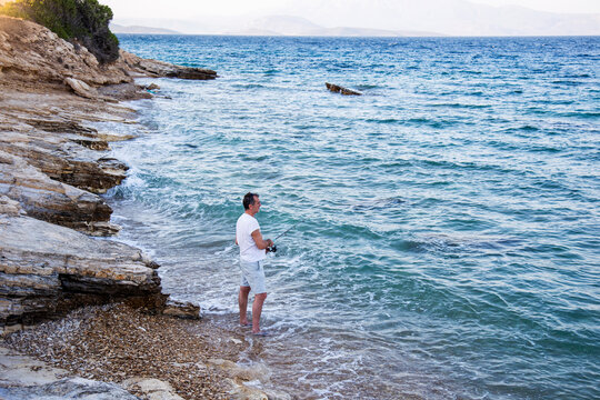 Focused fisherman by the sea with fishing rod