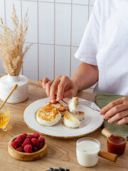 the girl has cheesecakes with berries for a healthy breakfast