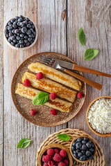 pancakes with cottage cheese and berries on a plate.