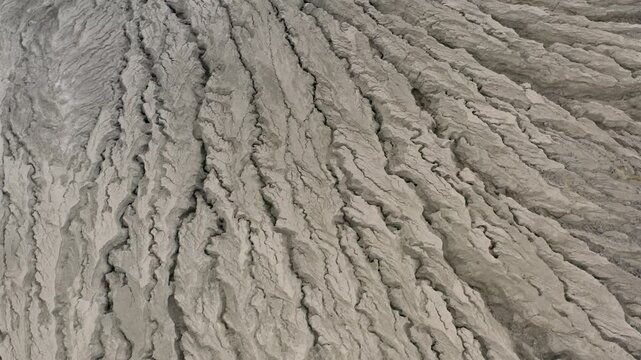 Aerial tilt-down view of abstract terrain patterns down side of Barcena volcano