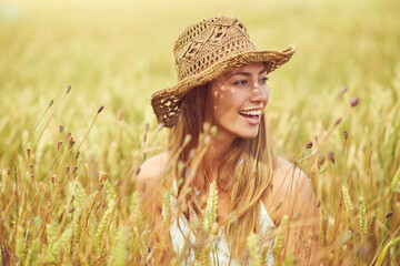 Smile, woman and thinking in wheat field for peace, growth and environment care in nature. Happy, relax and person in grain farm for agriculture, calm and positive mental health in summer with hat