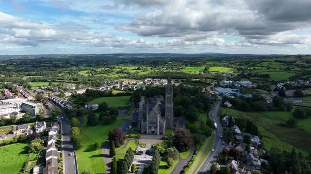 St. Macartan's Cathedral, County Monaghan, Ireland, September 2022. Drone orbits clockwise around the French Gothic architecture with sunlight breaking through clouds on a sunny afternoon.