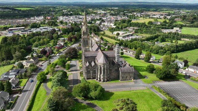 St. Macartan's Cathedral, County Monaghan, Ireland, September 2022. Drone orbits clockwise while pushing towards the Roman Catholic architecture with Monaghan town in the background on a sunny day.