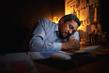 Fototapeta premium Mature businessman, sleeping and night with rest for burnout, stress or insomnia on office desk. Exhausted man or lazy employee asleep in late evening for nap by computer or technology at workplace