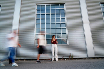 A group of people walking down a street with blurred faces