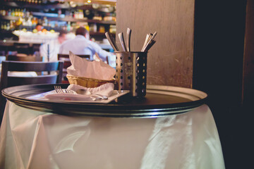 Restaurant service stand with a tray and utensils.