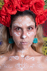 Portrait of a traditional mexican catrina wearing a crown with red roses on colorful cut paper background. Day of the Dead