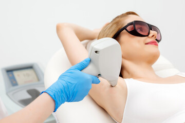Underarm laser hair removal in a beauty clinic. A professional cosmetologist performs a precise...