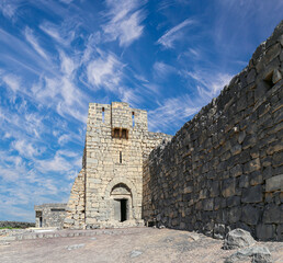 Ruins of Azraq Castle (Qasr al-Azraq) is a crusader castle (300AD),  central-eastern Jordan, 100 km east of Amman, Jordan. Against the background of a beautiful sky with clouds