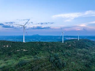 view of wind power station on hill at sunrise