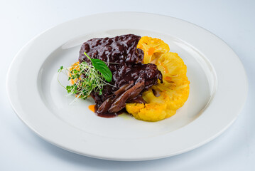 Dinner beef fillet steak in sauce with cauliflower and microgreens.