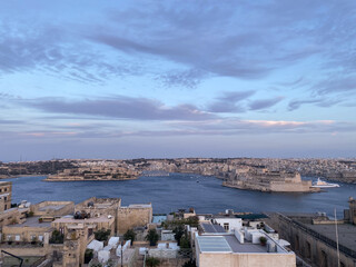 Fototapeta premium Skyline view of the beautiful coastal city of Valletta in Malta on a sunset sky