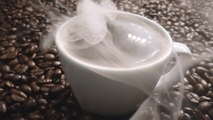 Top view of coffee or espresso with piles of coffee beans. Close up of fresh roasted coffee bean scatter around wooden table with cup of americano and aromatic stream and smoke from seed. Comestible.