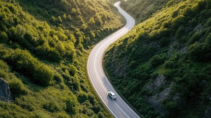 Aerial view of a car driving through a valley during a summer road trip