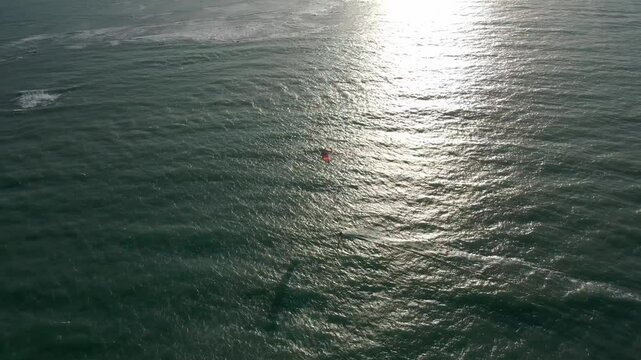 Pessoa velejando de Kitesurf no sunset no mar