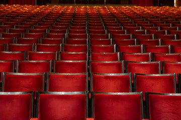 Naklejka premium Several red theater seats, with symmetrical framing between the chairs.