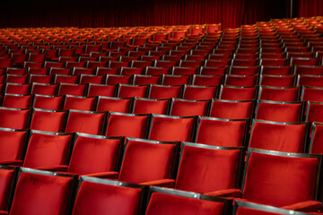Fototapeta premium Several red theater seats, with symmetrical framing between the chairs.
