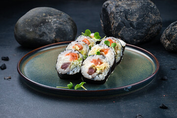Japanese sushi rolls with tuna, salmon, Philadelphia cheese, avocado and microgreens.