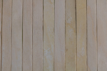 A close-up of the texture of popsicle sticks, showcasing their smooth and flat surface with visible wood grain patterns