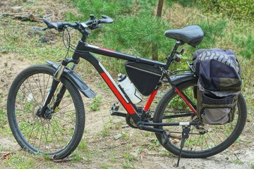 one sport modern iron mountain two wheel black with soft saddle and bag on trunk new bicycle standing on ground daytime outdoors