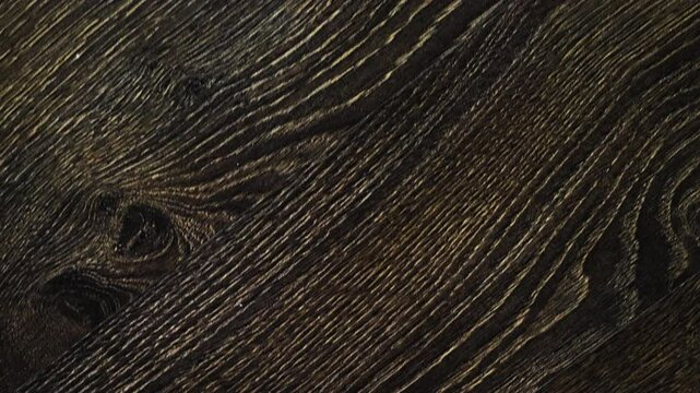 Laminate flooring in slow motion camera slide. The flooring is walnut texture, parquet on the floor, top view.