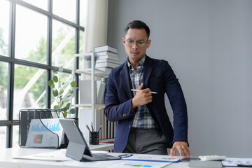 Businessman is holding his chest in pain while working at his desk in the office