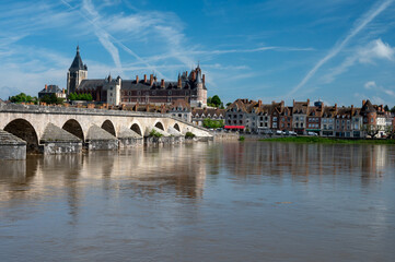 Obraz premium View.on old part of town of Gien on the Loire river, in Loiret department, France, houses with tiled roofs and chimneys, castle and bridge