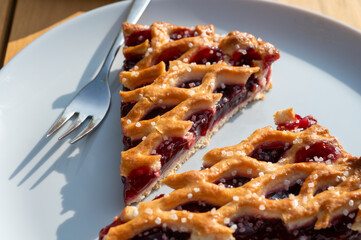 Homemade open sour cherry pie, delicious sweet dessert served in pieces outdoor in garden