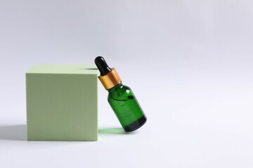 Skin care with cosmetic facial serum. Glass bottle with a pipette on a white  background. Dry skin care product. Essential oil for moisturizing the skin of the body. Brand layout.
