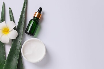 Skin care with cosmetic facial aloe serum and cream. Glass bottle with a pipette on a white background. Dry skin care products. Essential oil for moisturizing the skin of the body.