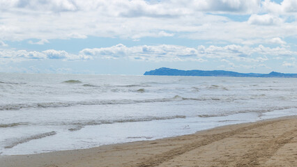 Serene Seascape: A Sandy Shore Bathed in Sunlight