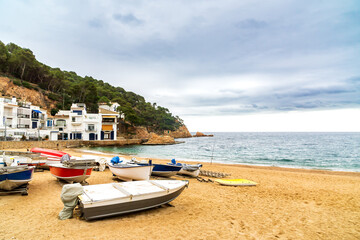 Boats on the beach of Begur, Costa Brava, Spain, on a cloudy day.