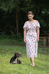 Beautiful young girl with American Staffordshire Terrier in nature.